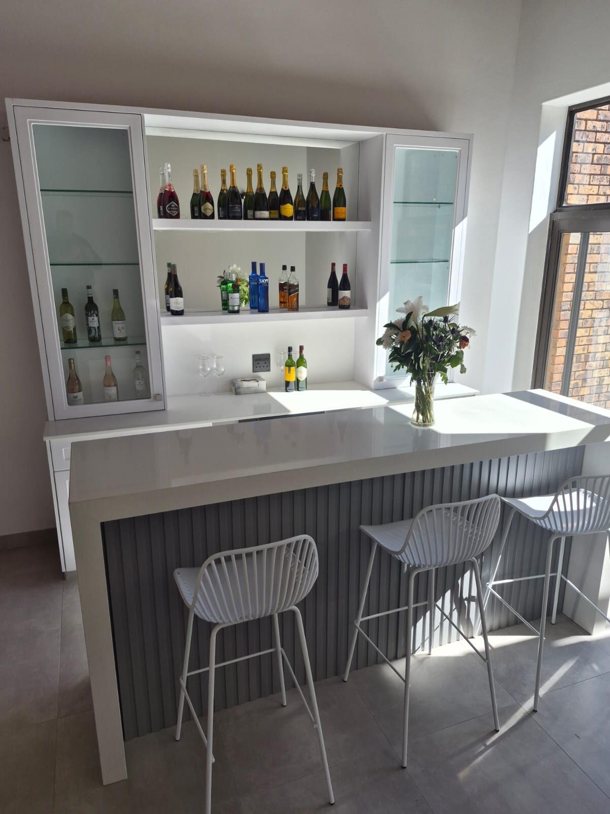 Glossy white bar hutch with glass display doors