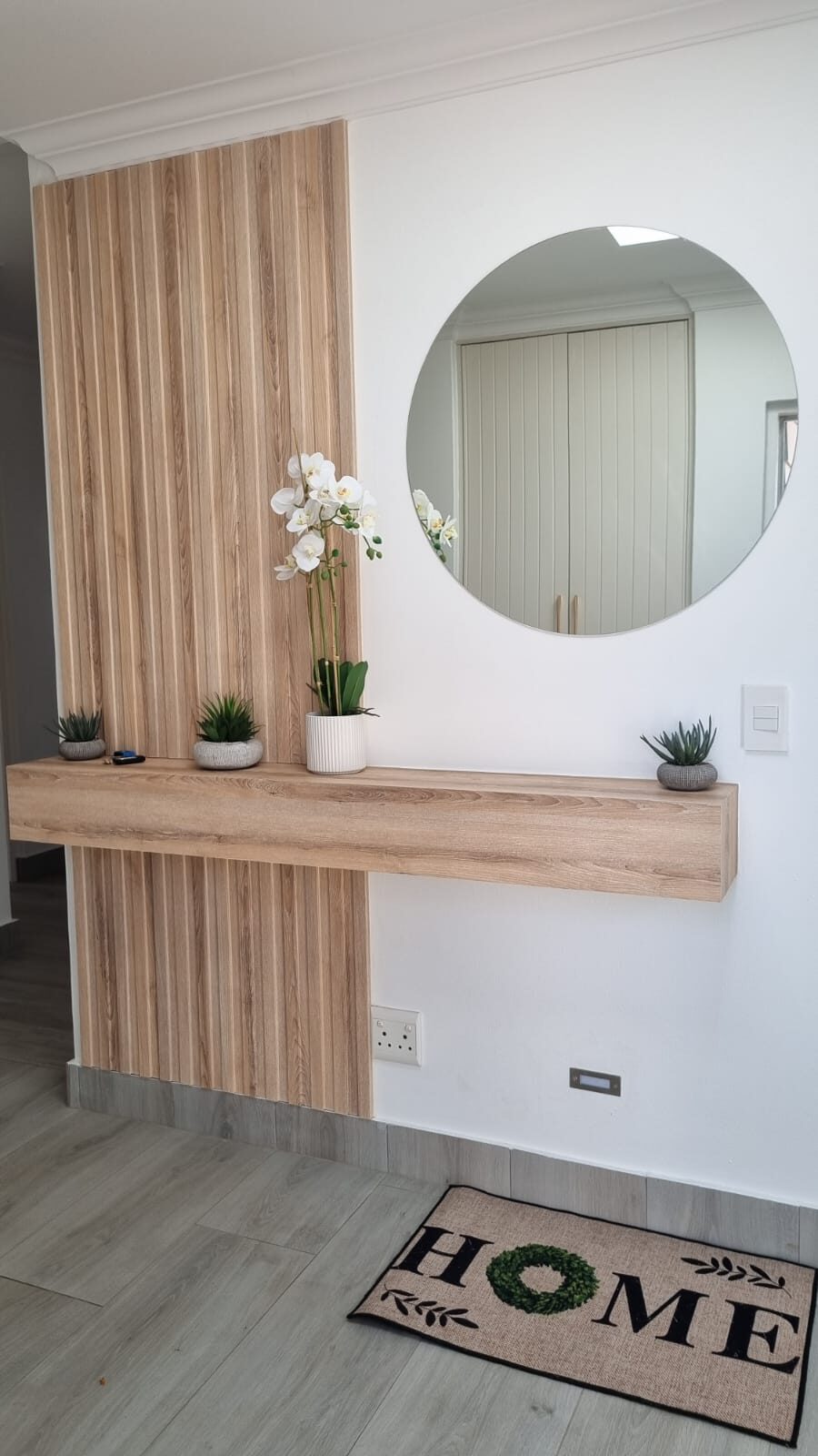 Floating oak slat console in entrance hall