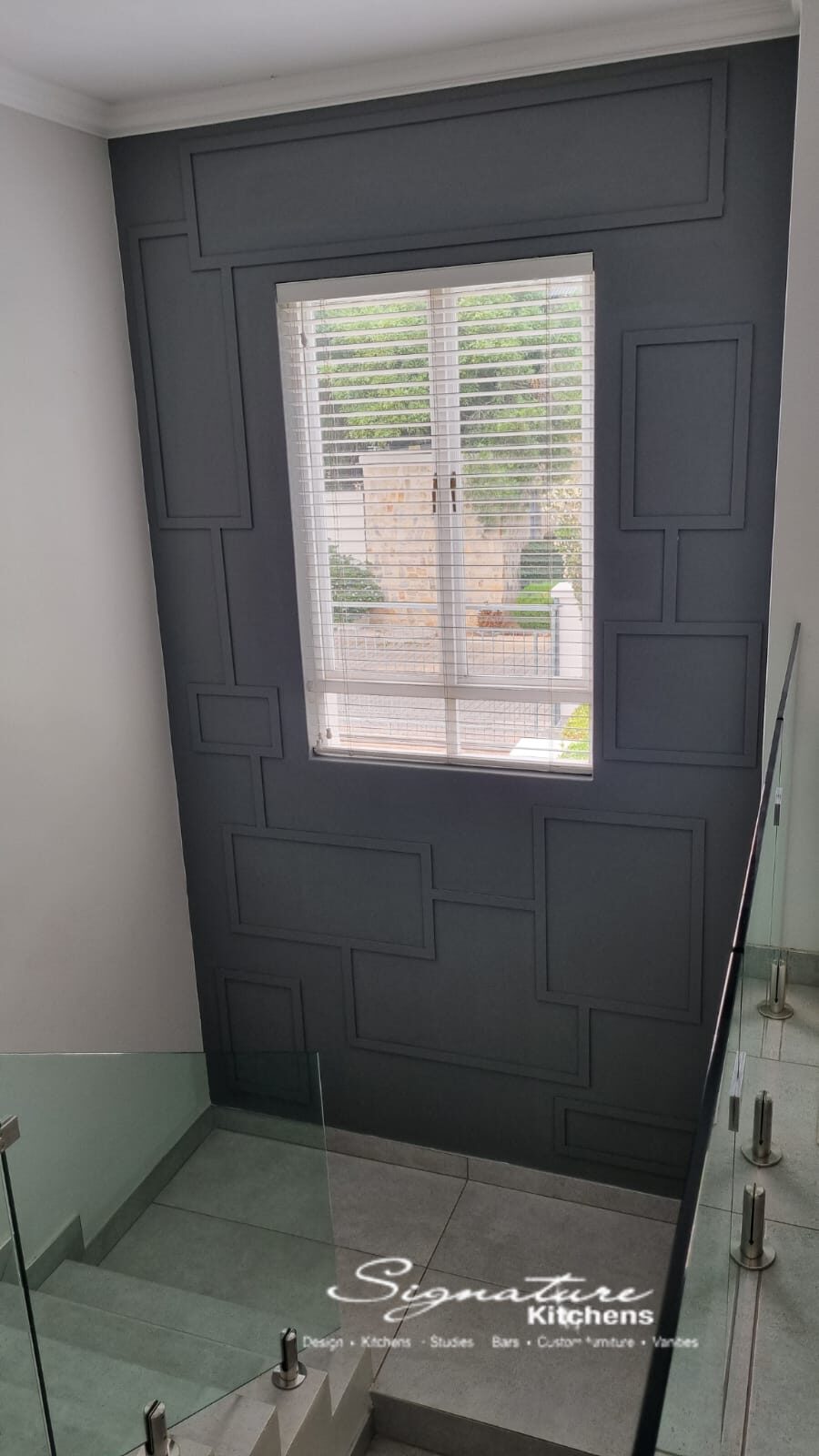 Dark panelled feature wall on a stairwell landing